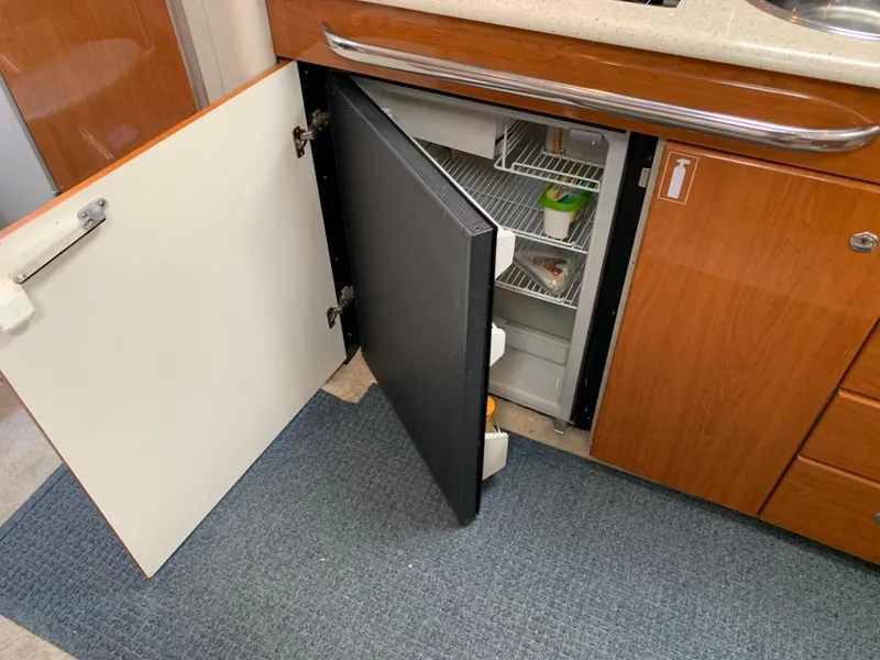 Slide: The Image of Small refrigerator in 2005 Formula 34 Performance Cruiser's wooden interior kitchen area. - 30