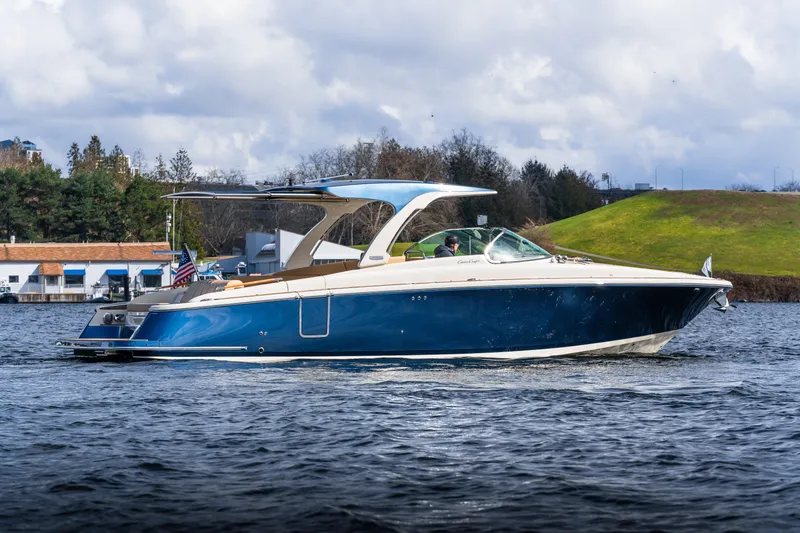Slide: The Image of 2025 Chris-Craft Launch 35 GT boat cruising on a scenic lake. - 1