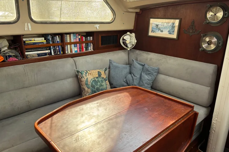 Slide: The Image of Cozy 1984 Stamas 44 yacht interior with books, cushions, and wooden table. - 18