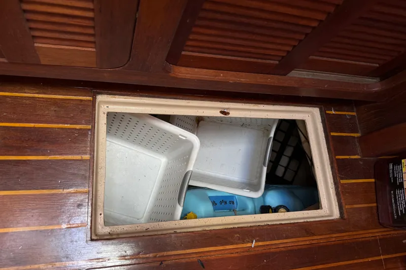 Slide: The Image of Storage compartment on 1984 Stamas 44 boat with plastic bins and containers. - 30