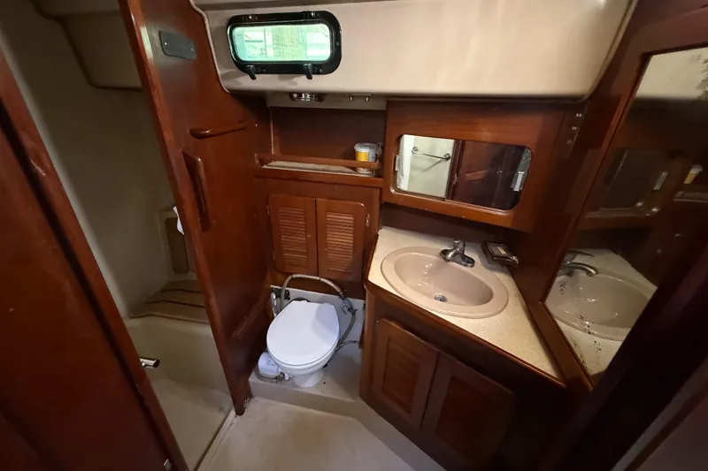 Slide: The Image of 1984 Stamas 44 yacht bathroom with wooden cabinetry, sink, and toilet. - 31