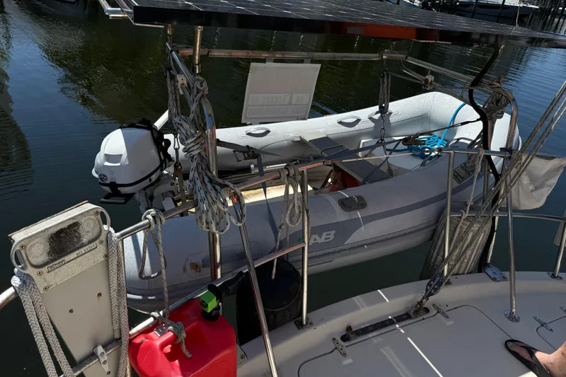 Slide: The Image of 1984 Stamas 44 boat with dinghy and solar panel, docked in calm waters. - 6