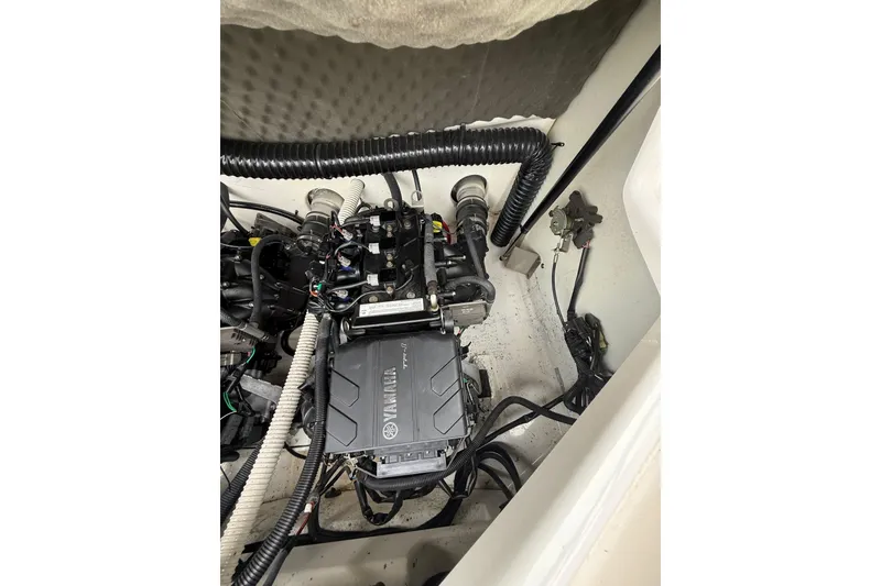 Slide: The Image of Engine compartment of a 2019 Yamaha Boats AR210, showcasing mechanical components and wiring. - 16
