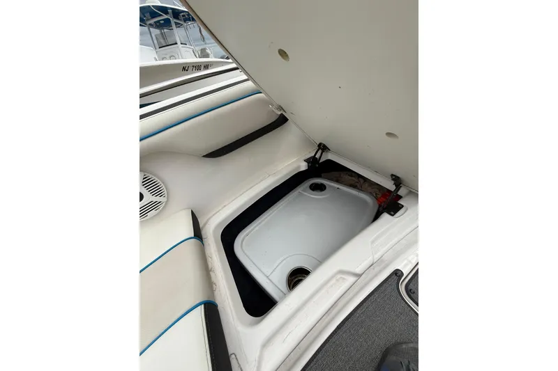 Slide: The Image of 2019 Yamaha Boats AR210 storage compartment with open hatch, showcasing interior details. - 35