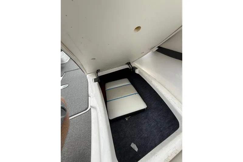 Slide: The Image of 2019 Yamaha AR210 boat storage compartment with cushioned interior and carpeted flooring. - 36