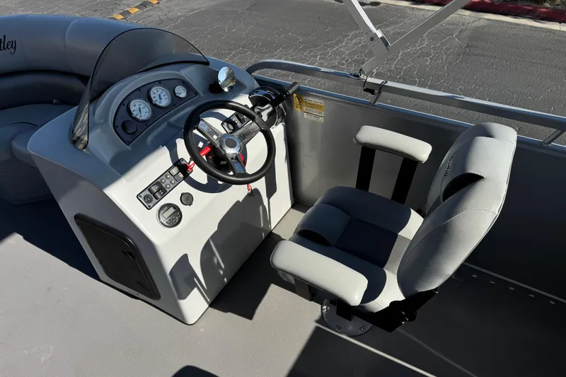 Slide: The Image of 2018 Bentley Pontoons 180 CRUISE helm with steering wheel and gauges, featuring comfortable seating. - 17