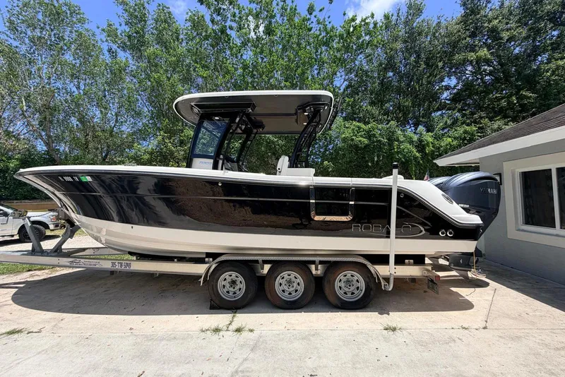 The Image of 2022 Robalo R302 Center Console boat on trailer, parked outdoors. - 1