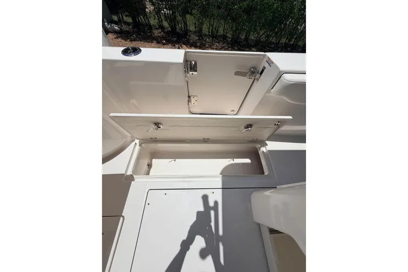 Slide: The Image of 2022 Robalo R302 Center Console boat storage compartments open on deck. - 11