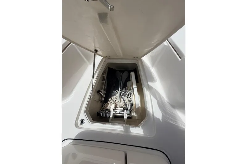 Slide: The Image of 2022 Robalo R302 Center Console storage compartment with ropes and equipment. - 13