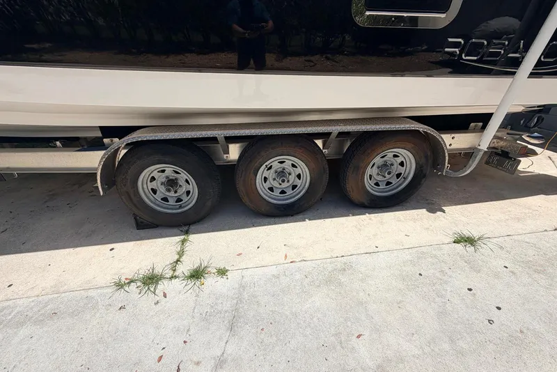 Slide: The Image of Trailer with three wheels supporting a 2022 Robalo R302 Center Console boat. - 16