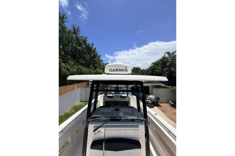 Slide: The Image of 2022 Robalo R302 Center Console boat with Garmin equipment, parked outdoors under a clear sky. - 22