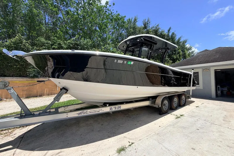 Slide: The Image of 2022 Robalo R302 Center Console boat on trailer, parked outdoors. - 5