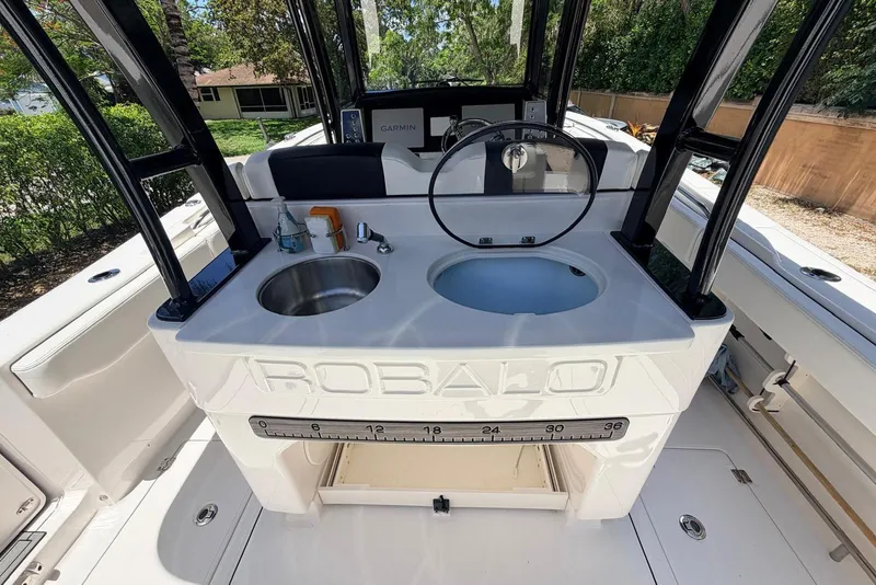 Slide: The Image of 2022 Robalo R302 Center Console boat with sink and storage area. - 8