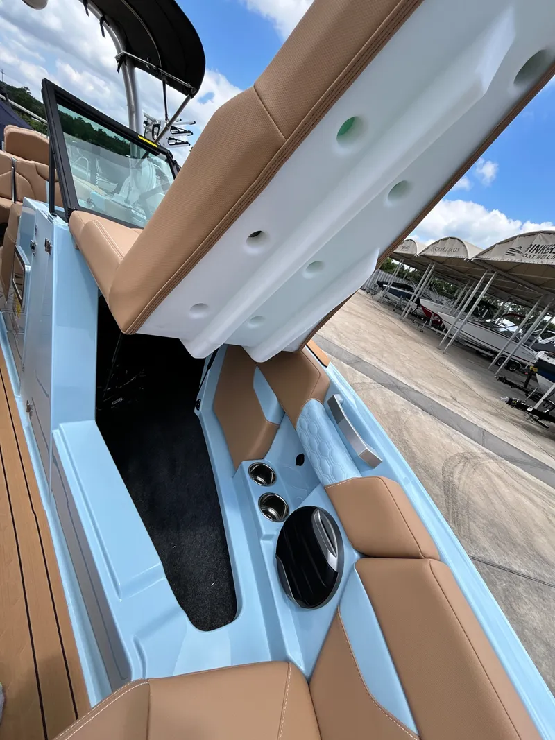 Slide: The Image of Interior view of 2026 MasterCraft XT23 boat with blue and brown seating. - 24