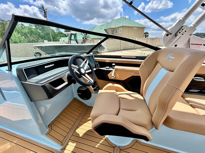 Slide: The Image of Interior of 2026 MasterCraft XT23 with modern steering wheel and leather seats. - 29