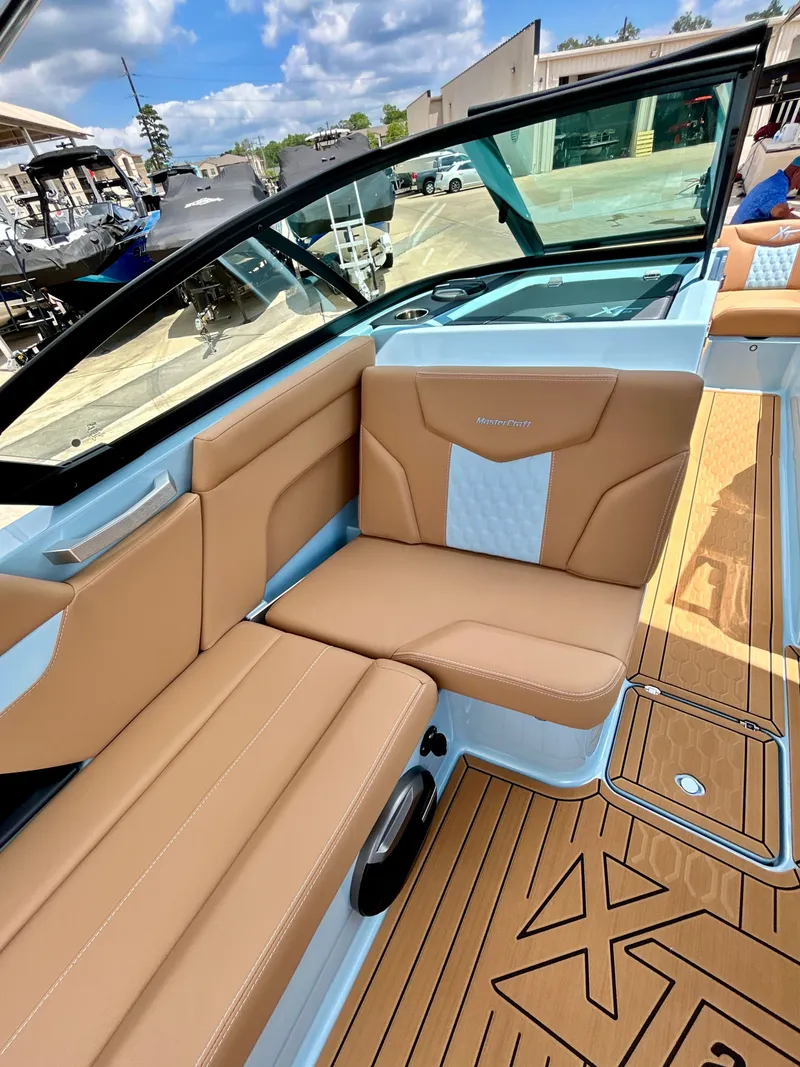 Slide: The Image of Interior of 2026 MasterCraft XT23 with beige seats and wood flooring. - 32