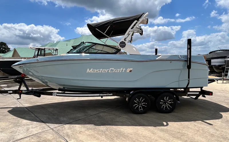 Slide: The Image of 2026 MasterCraft XT23 boat on trailer under blue sky. - 4