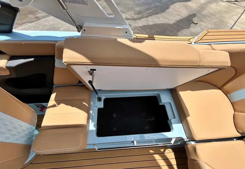 Slide: The Image of 2026 MasterCraft XT23 boat with open storage compartment and leather seats. - 46
