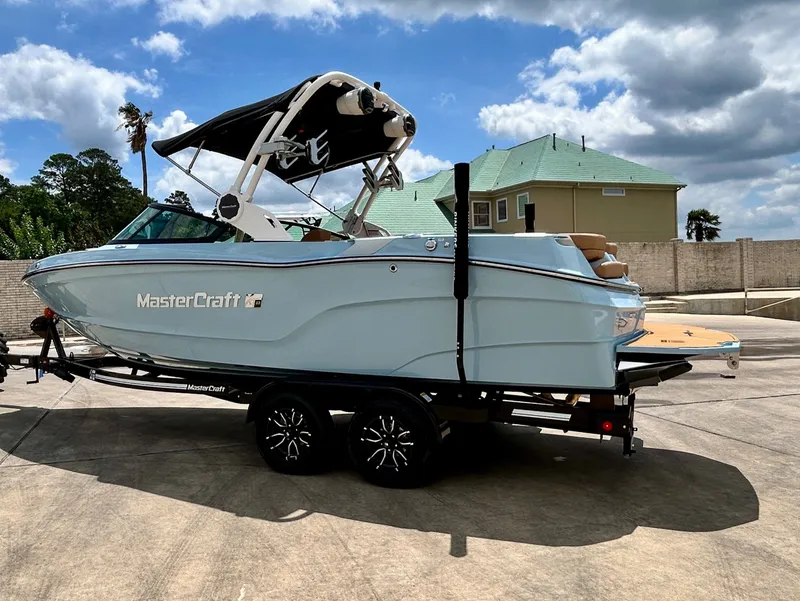 Slide: The Image of 2026 MasterCraft XT23 boat on trailer in sunny weather. - 8