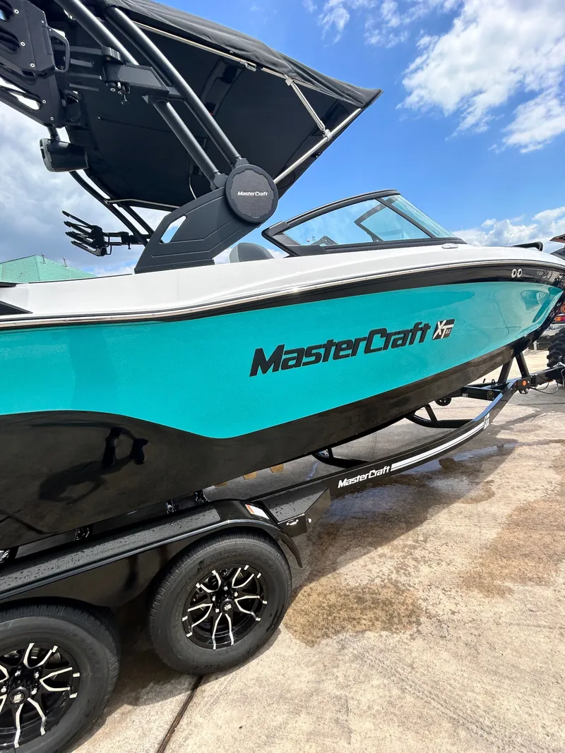 Slide: The Image of 2026 MasterCraft XT22 boat on trailer under blue sky. - 16