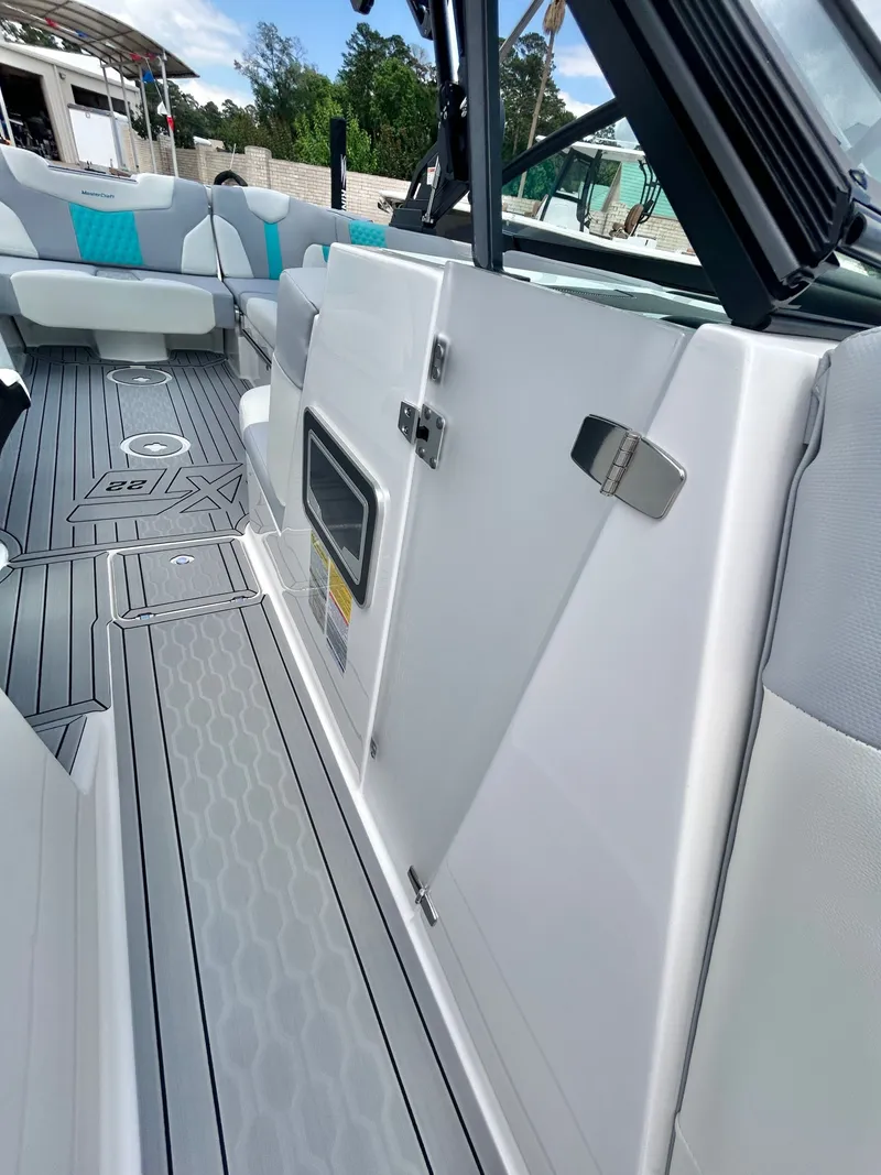 Slide: The Image of Interior of a 2026 MasterCraft XT22 boat with gray and blue seating. - 25