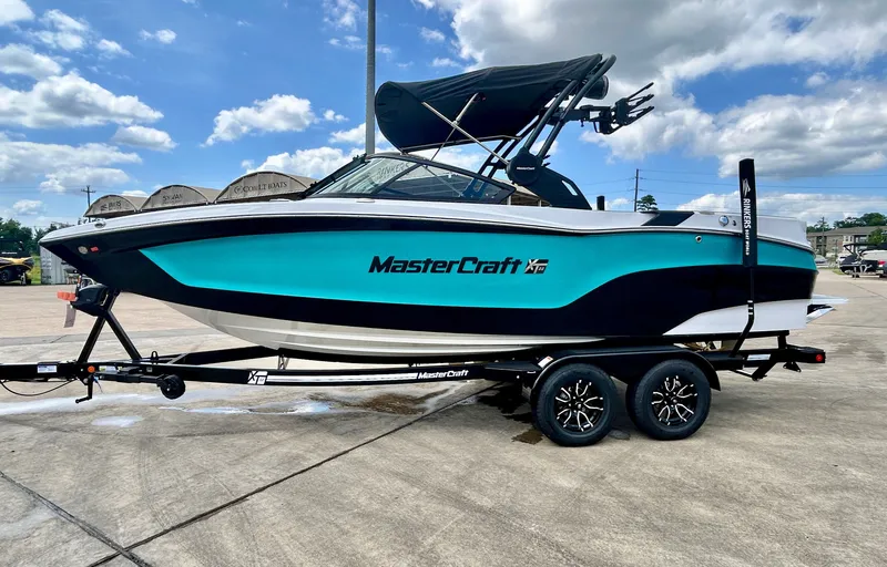 Slide: The Image of 2026 MasterCraft XT22 boat on trailer under blue sky. - 3