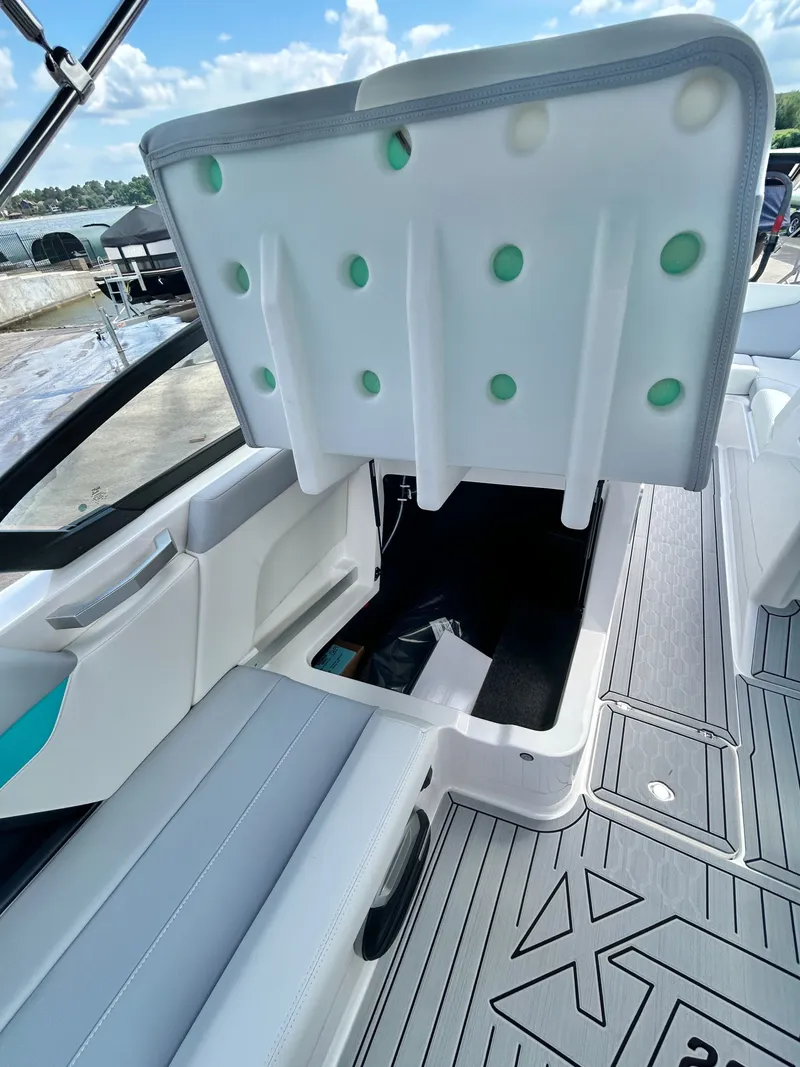 Slide: The Image of 2026 MasterCraft XT22 boat with open storage compartment lid. - 34