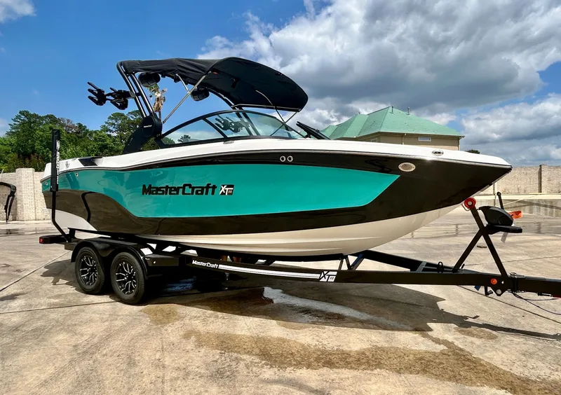 Slide: The Image of 2026 MasterCraft XT22 boat on trailer under blue sky. - 6