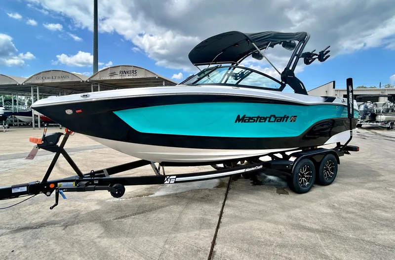 Slide: The Image of 2026 MasterCraft XT22 boat on trailer, blue and black, at Rinkers Boat World. - 7