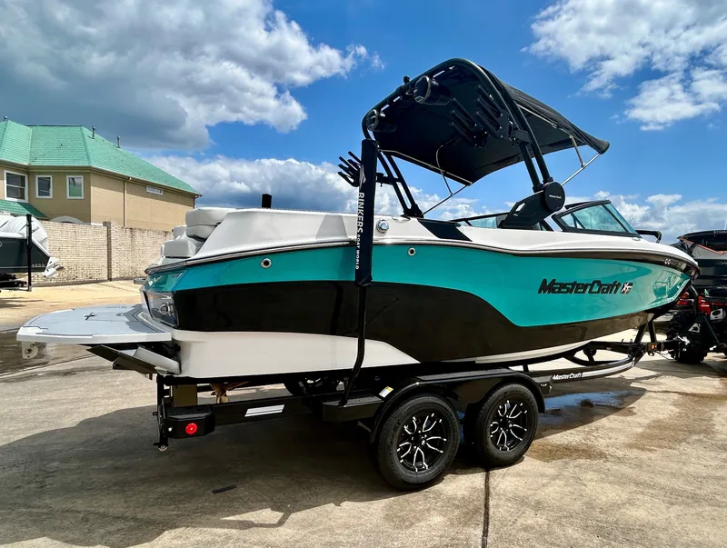 Slide: The Image of 2026 MasterCraft XT22 boat on trailer in sunny weather. - 8