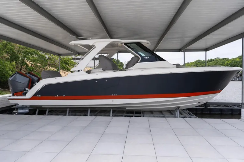 The Image of 2026 Tiara Yachts 34 LS boat docked under a covered marina. - 0