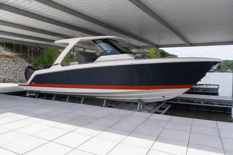 Slide: The Image of 2026 Tiara Yachts 34 LS boat docked under a covered marina. - 1