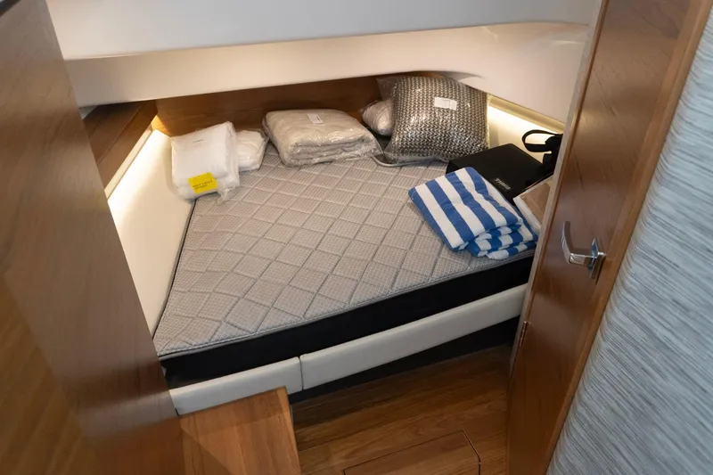 Slide: The Image of Cozy cabin interior of 2026 Tiara Yachts 34 LS with bedding and striped towel. - 14