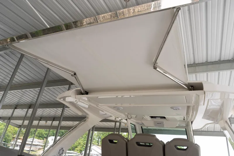 Slide: The Image of Tiara Yachts 34 LS 2026 model with retractable sunshade under a covered dock. - 7