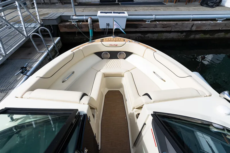 Slide: The Image of 2025 Chris-Craft Sportster 25 boat interior with cream seating, docked at marina. - 11