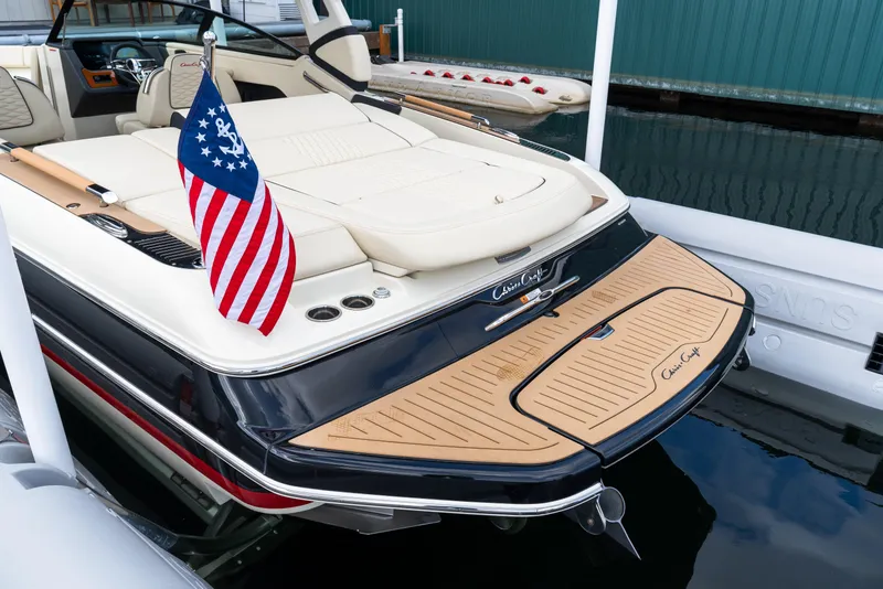Slide: The Image of 2025 Chris-Craft Sportster 25 boat docked, featuring elegant design and American flag. - 12