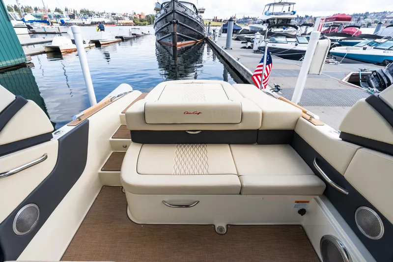 Slide: The Image of 2025 Chris-Craft Sportster 25 boat interior at marina, featuring elegant seating and American flag. - 5