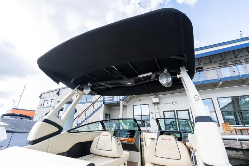 Slide: The Image of 2025 Chris-Craft Sportster 25 boat with sleek design and modern features at a marina. - 6