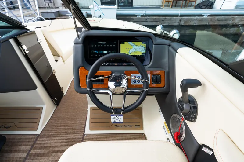 Slide: The Image of 2025 Chris-Craft Sportster 25 cockpit with modern steering wheel and navigation display. - 9