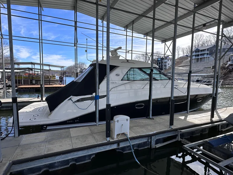 The Image of 2012 Sea Ray 450 Sundancer yacht docked in a marina under a covered structure. - 0