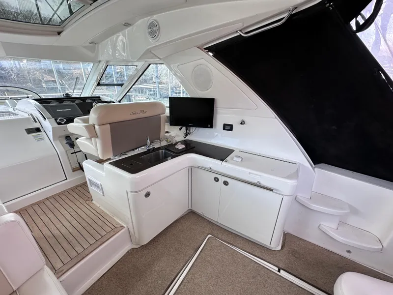 Slide: The Image of 2012 Sea Ray 450 Sundancer interior with helm, seating, and entertainment area. - 14