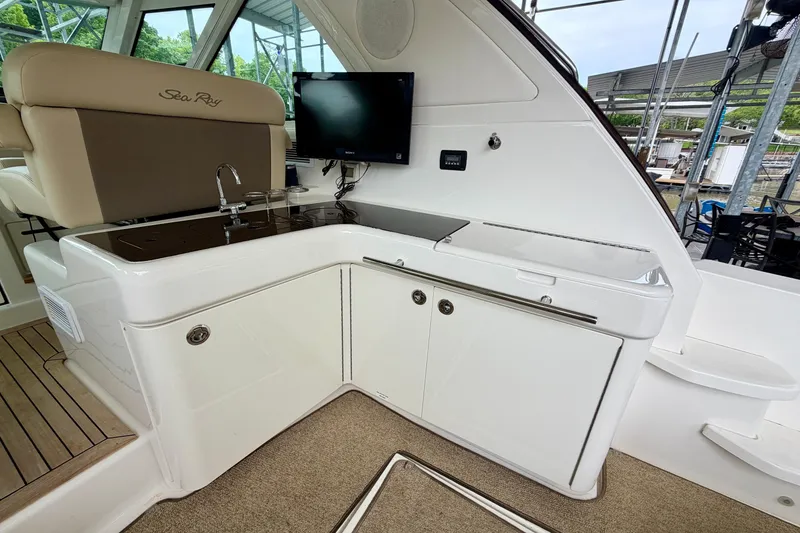 Slide: The Image of Interior of 2012 Sea Ray 450 Sundancer yacht with kitchenette and seating area. - 15