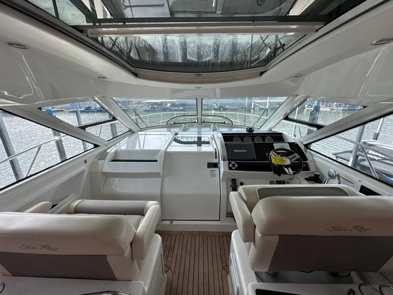 Slide: The Image of Interior view of 2012 Sea Ray 450 Sundancer yacht cockpit with helm and seating. - 21