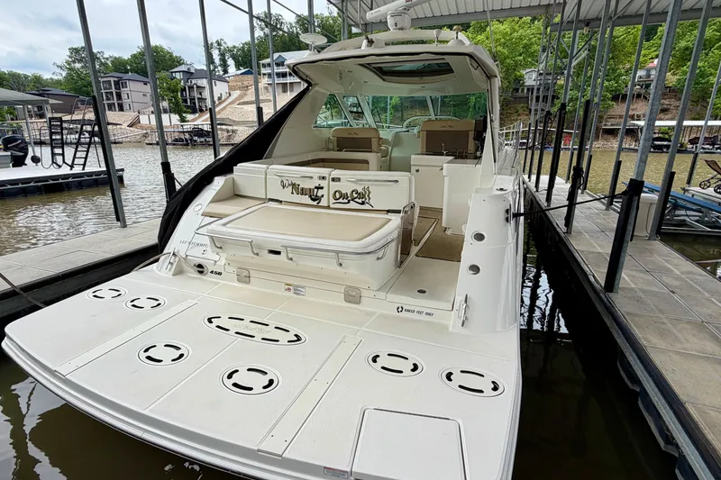 Slide: The Image of 2012 Sea Ray 450 Sundancer docked, showcasing spacious deck and luxurious seating. - 3