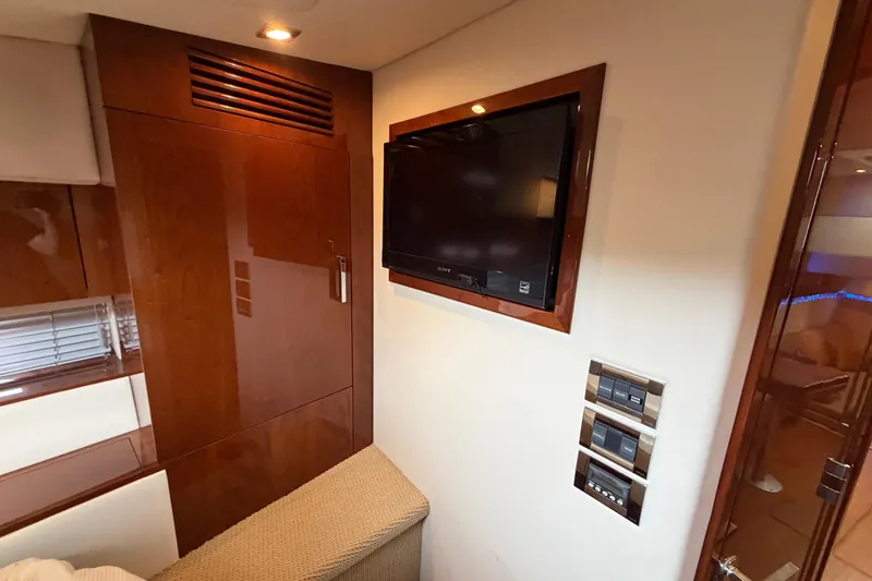 Slide: The Image of Luxurious interior of 2012 Sea Ray 450 Sundancer with TV and wooden cabinetry. - 38