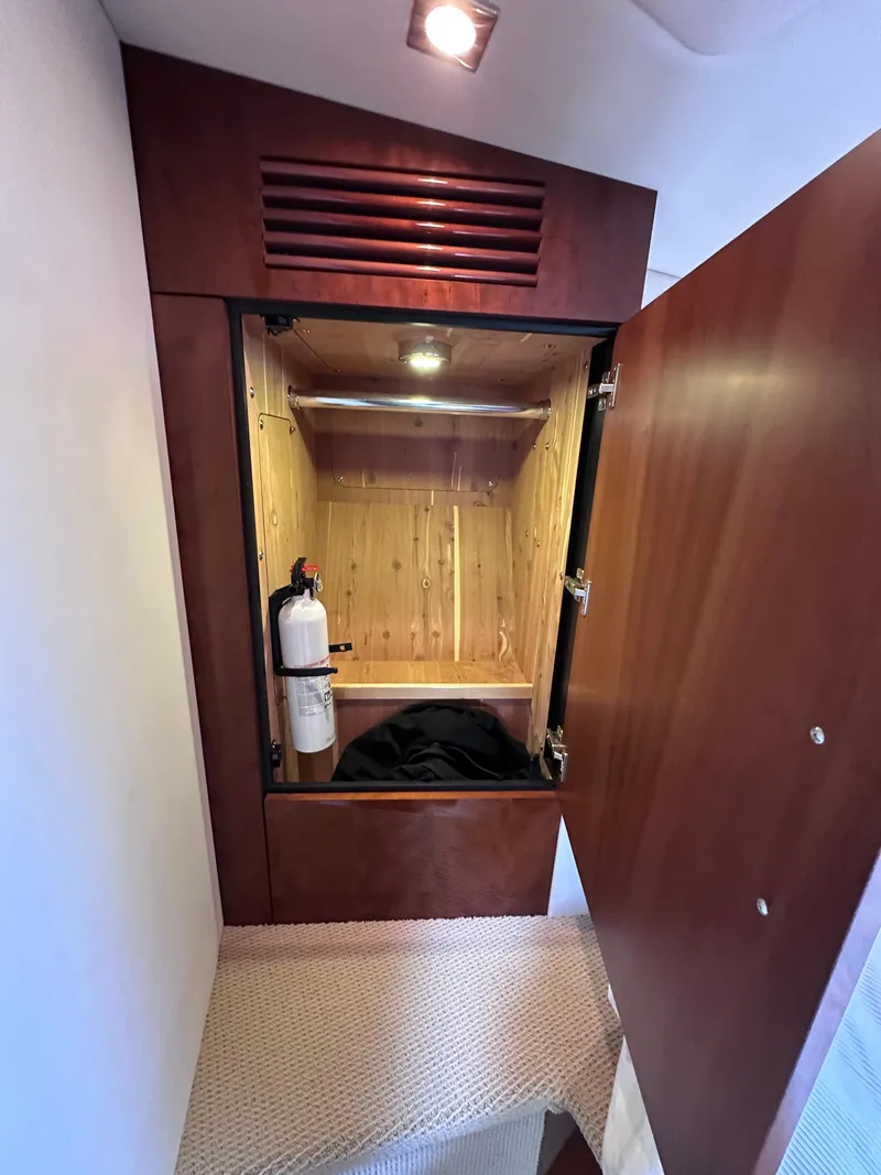 Slide: The Image of Open wooden cabinet with fire extinguisher inside Sea Ray 450 Sundancer yacht, 2012 model. - 39