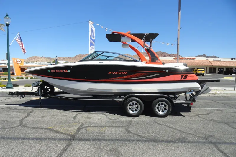 The Image of 2016 Four Winns TS222 boat on trailer, parked in sunny urban setting. - 1