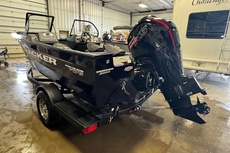 Slide: The Image of 2026 Tracker Pro Guide V-175 WT boat in a garage, featuring a powerful outboard motor. - 3