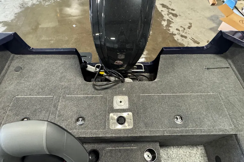 Slide: The Image of 2026 Tracker Pro Guide V-175 WT boat interior with motor and carpeted deck. - 8