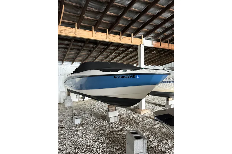 The Image of 2012 Bayliner 235 Bowrider stored indoors on cinder blocks. - 1